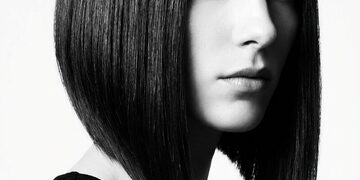 Stylish woman with asymmetrical bob at outdoor cafe terrace