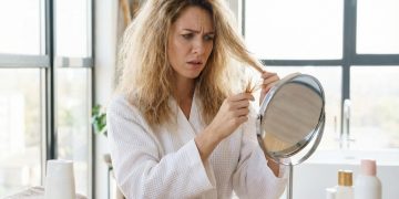 Woman with damaged unhealthy hair looking at split ends 2026